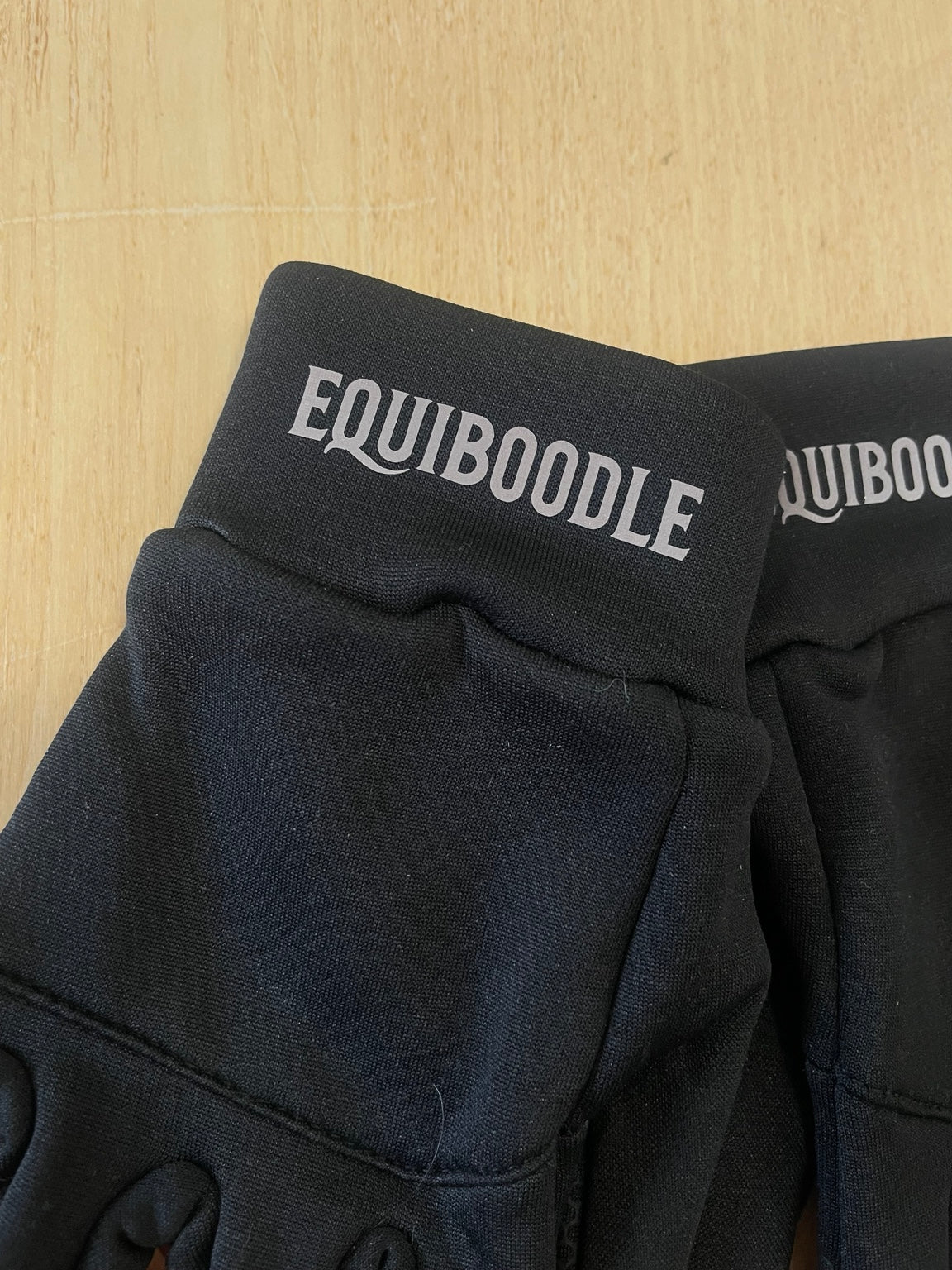 Close-up of Equiboodle reflective wordmark on softshell glove cuff